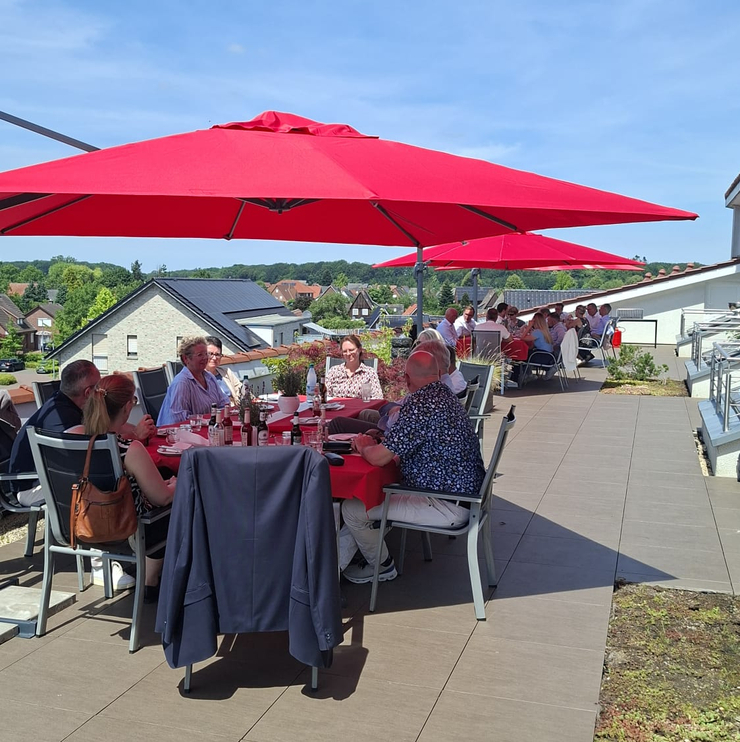 Blick auf der Dachterrasse wo alle an den Tischen sitzen